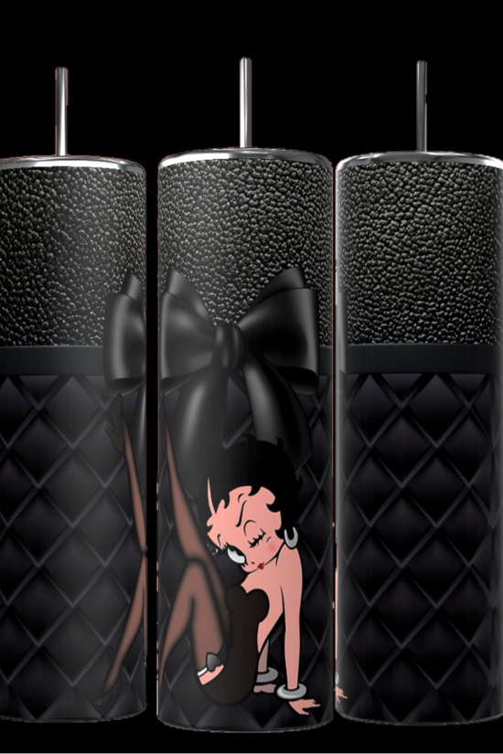 The Betty 20oz Skinny Tumbler by Kreative Kreationz features a black quilted texture with a silver lid and straw, showcasing Betty Boop in a pink dress on a bold black bow backdrop. Its spill-proof lid prevents leaks while you enjoy your drink.