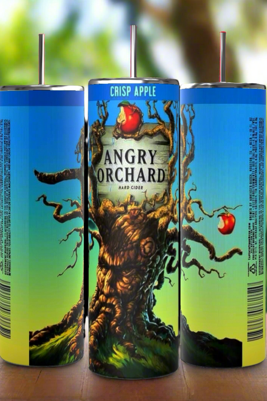 Three cans of Angry Orchard Crisp Apple Hard Cider are arranged with their labels showing. The central can features the Angry Orchard logo with an illustration of a gnarled tree with apples. The background is a blurred image of a sunny orchard, next to a Kreative Kreationz product: the Angry Orchard 20oz Tumbler boasting durable construction and 20 oz capacity.
