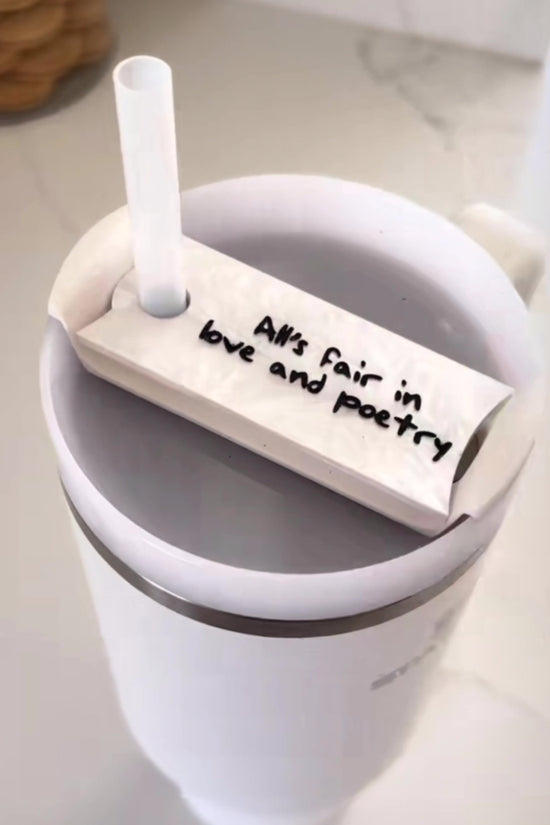 Stanley tumbler with showcasing white lid topper that says “alls fair in love and poetry” from taylor swifts album TTPD