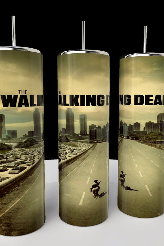 Kreative Kreationz's The Walking Dead 20oz Skinny Tumblers feature an eco-friendly design of an apocalyptic cityscape with a lone figure on horseback navigating a traffic-jammed highway under cloudy skies.