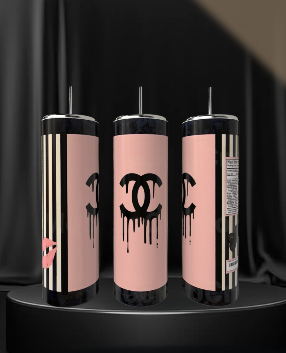 Three Chanel 20oz Skinny Tumblers by Kreative Kreationz, featuring pink and black designs with a dripping Chanel logo, lipstick print, stripes, and a nutrition label, rest stylishly on a black pedestal—eco-friendly drinkware for any occasion.