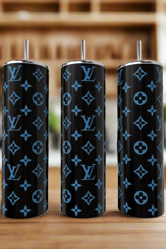 Three LV Inspired Dark Blue 20oz Tumblers by Kreative Kreationz, designed with luxury blue Louis Vuitton logos and floral accents, are displayed side by side on wood with a blurred kitchen background.
