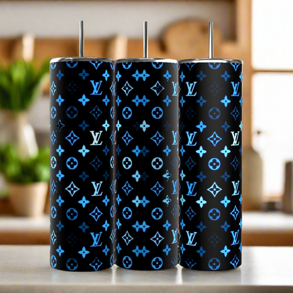 Three Kreative Kreationz Multi Blue LV 20oz Tumblers with metal straws are side by side. Their luxury-inspired black design features blue and white patterns with "LV" letters. The reusable, eco-friendly set is in a softly blurred kitchen background.