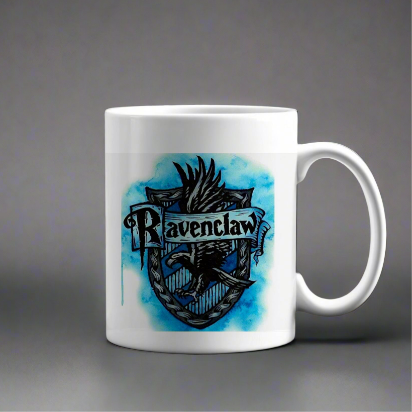 The Ravenclaw Ceramic Mug by Kreative Kreationz is an eco-friendly ceramic mug featuring the Ravenclaw crest, a blue watercolor background, and a black eagle below the word "Ravenclaw.