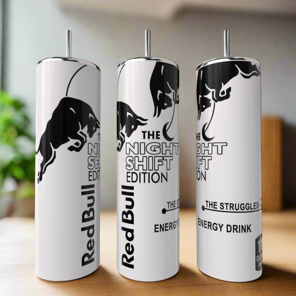 Three tall, white Red Bull Night Shift Edition 20oz Tumblers by Kreative Kreationz stand on a wooden surface, featuring a luxury-inspired design with a black bull and bold black text. A blurred plant appears in the background.