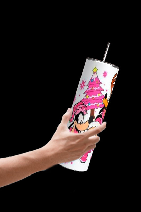 A hand holding a Pink Disney Christmas 20oz Tumbler by Kreative Kreationz, featuring a durable design adorned with colorful cartoon characters and a pink Christmas tree motif. The solid black background accentuates the whimsical artistry and charming details of the tumbler.