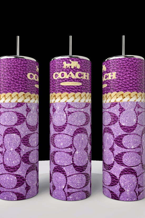 Three tall Kreative Kreationz Coach 20oz Skinny Tumblers featuring purple Coach logo patterns, gold accents, and metallic straws are showcased on a white surface with a black background, exemplifying chic luxury drinkware.