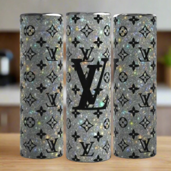 Three Kreative Kreationz Louis Vuitton Shimmer 20oz Tumblers with silver glitter finish, black LV-inspired logos, and monogram patterns are displayed on a wooden surface against a blurred kitchen background.