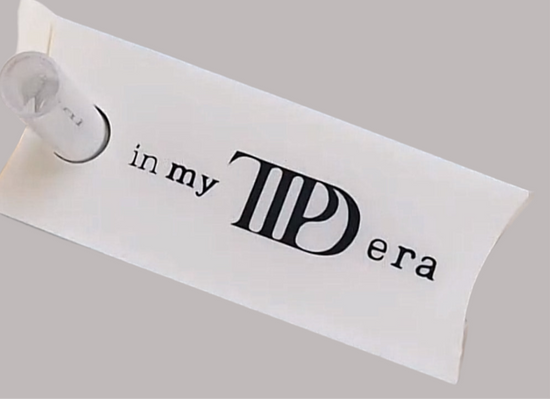 A white rectangular paper pouch contains the In My TTPD Era Tumbler Lid Topper by Kreative Kreationz, designed for 20, 30, and 40 oz Stanley tumblers. The pouch reads 