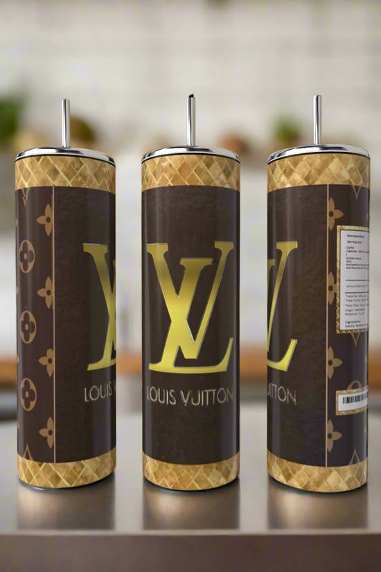 Three Louis V 20oz Skinny Tumblers by Kreative Kreationz, each with a brown and gold luxury-inspired design and logo, are shown side by side on a kitchen counter. These reusable tumblers with straws add style to your drinkware collection.