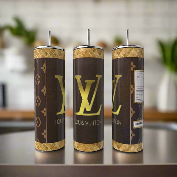 Three Louis V 20oz Skinny Tumblers by Kreative Kreationz, each with a brown and gold luxury-inspired design and logo, are shown side by side on a kitchen counter. These reusable tumblers with straws add style to your drinkware collection.