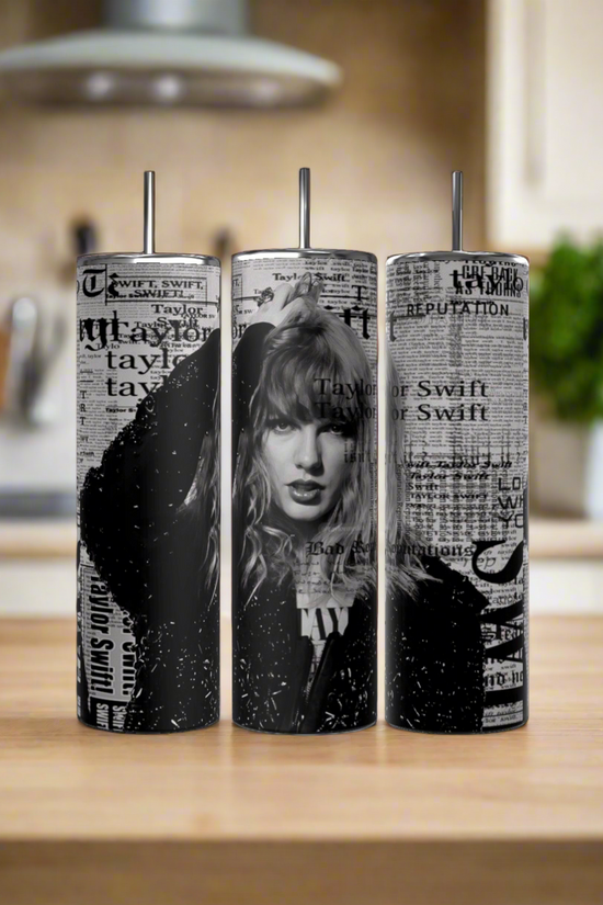 Three Kreative Kreationz Taylor Swift Reputation Newspaper 20oz Tumblers, each with black-and-white images and newspaper-style text plus spill-proof lids and reusable straws, are displayed on a wooden kitchen counter with a softly blurred background.