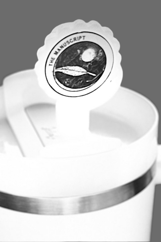 The white Stanley tumbler has a lid adorned with a round sticker featuring a celestial design and 