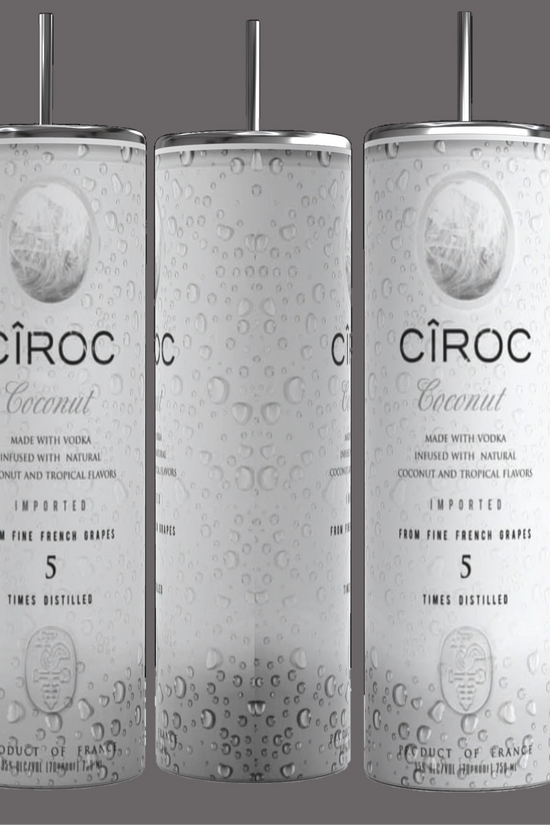 Two cans of Kreative Kreationz Ciroc 20oz Tumbler with 3D Lid Topper are shown on a wooden surface, reminiscent of travel tumblers. The left can is Red Berry flavor, topped with ice and a cherry. The right can is Vodka Snap Frost flavor, topped with ice and a lemon slice. Both cans feature product information and branding.