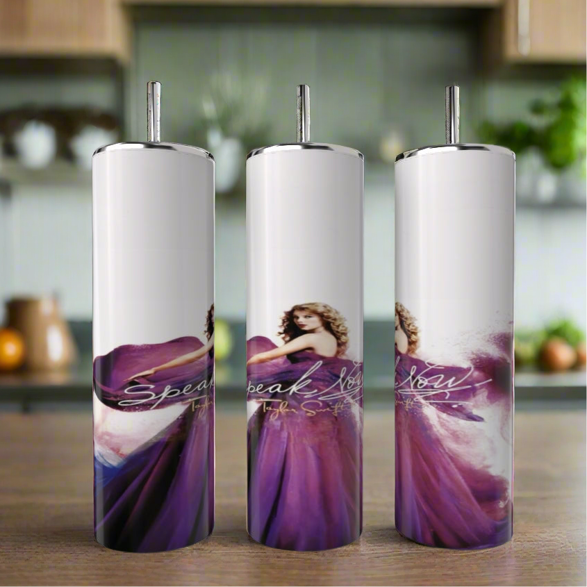 The Kreative Kreationz Speak Now Taylor’s Version 20oz Tumblers feature a woman in a flowing purple dress with curly hair, set against a blurred kitchen background and display “Speak Now” in elegant cursive for stylish, eco-friendly drinkware.