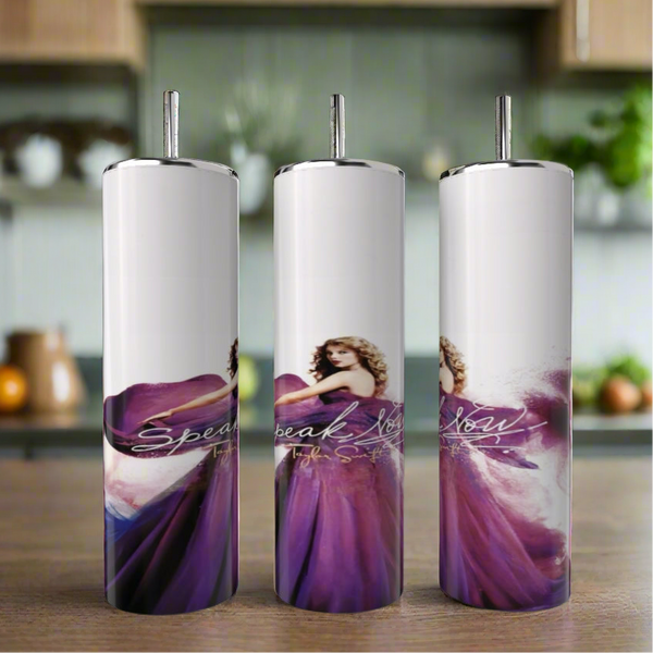 The Kreative Kreationz Speak Now Taylor’s Version 20oz Tumblers feature a woman in a flowing purple dress with curly hair, set against a blurred kitchen background and display “Speak Now” in elegant cursive for stylish, eco-friendly drinkware.