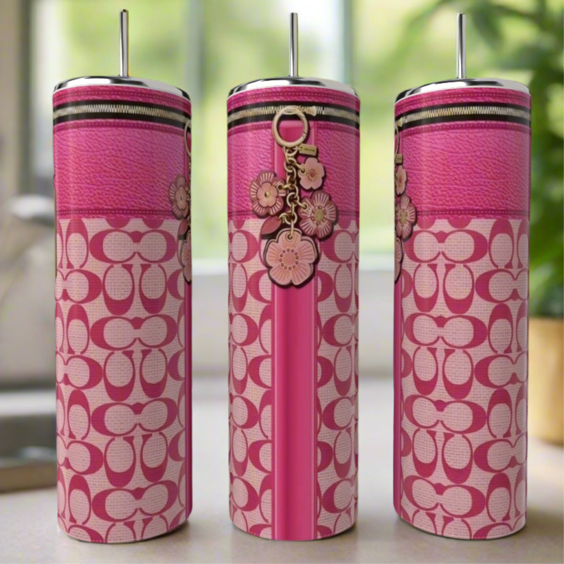 Three Coach 20oz Tumblers by Kreative Kreationz, featuring pink patterned stainless steel and metallic straws, are displayed with floral keychain accents against a blurred green and beige background.
