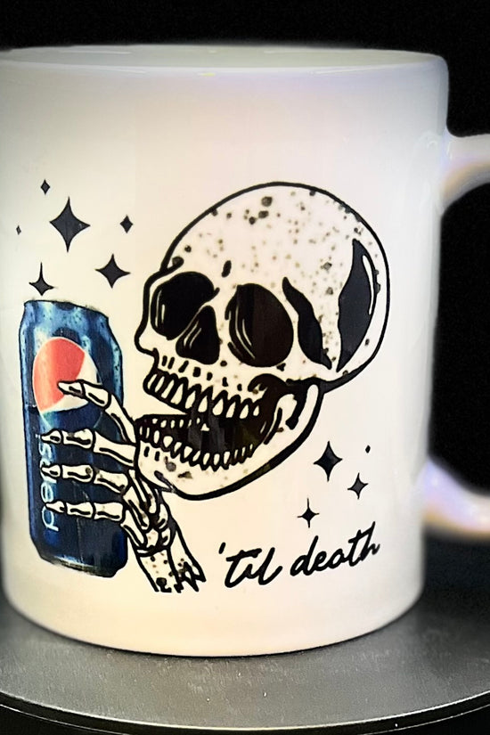 Introducing the Pepsi to death Skull Ceramic Mug by Kreative Kreationz: This ceramic mug features a grinning skull holding a Pepsi can with its skeletal hand, along with the phrase 