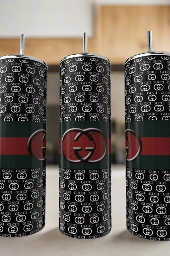 Three Gucci Dark 20oz Skinny Tumblers by Kreative Kreationz are shown. Each features a black base, repeating white “GG” pattern, a red and green stripe, and a large central “GG” logo, complete with metal straws.