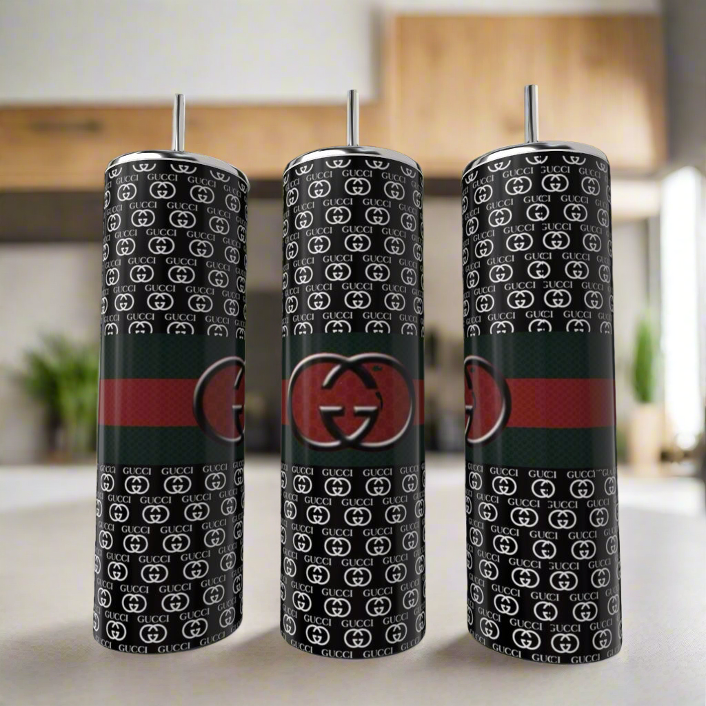 Three Gucci Dark 20oz Skinny Tumblers by Kreative Kreationz are shown. Each features a black base, repeating white “GG” pattern, a red and green stripe, and a large central “GG” logo, complete with metal straws.