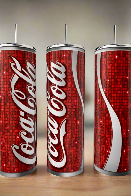 Three Cola 20oz Skinny Tumblers by Kreative Kreationz, featuring red designs with white logos and a sparkling sequin-style background, stand on a wooden surface—ideal as stylish, eco-friendly drinkware alternatives.