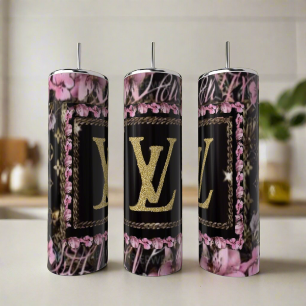 Three Kreative Kreationz LV Pink & Black 20oz Tumblers, featuring pink floral and black designs with a gold “LV” logo, exemplify luxury drinkware as they sit on a light countertop in a softly blurred kitchen setting.