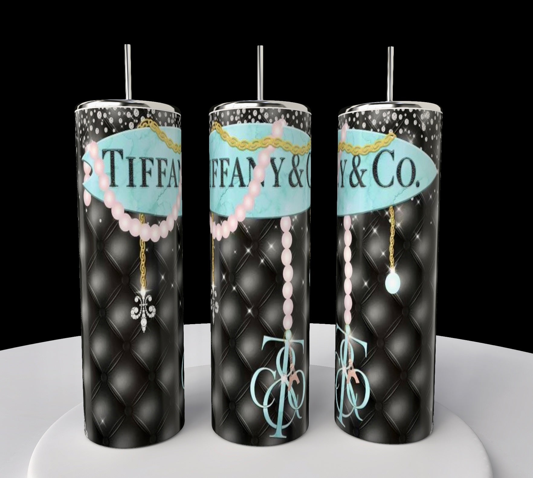 Three tall Kreative Kreationz Tiffany 20oz Tumblers with black quilted patterns, blue "Tiffany & Co." logos, pink pearl necklaces, gold chains, and stainless steel straws are displayed on a white surface against a black background.