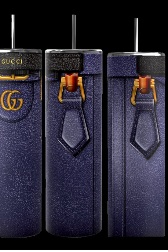 Three tall, cylindrical Gucci Diana-inspired purple tumblers from Kreative Kreationz, featuring a leather-like texture, gold Gucci logos, and black straws, stand on a cobblestone street. With durable construction and a 20 oz capacity, the focus remains on these stylish and luxurious cups against the softly blurred background.
