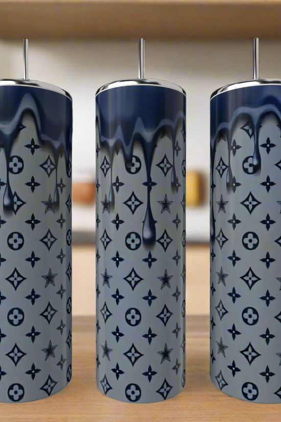 Three Dallas Cowboys LV Drip 20oz Tumblers by Kreative Kreationz stand on a wooden surface. Each stainless steel tumbler features a gray base, dark blue drip design, and repeating star and floral patterns. A kitchen is blurred in the background.