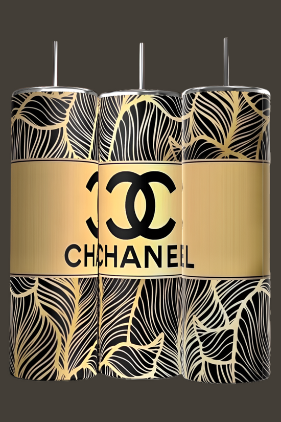 Three cylindrical, eco-friendly 20oz skinny tumblers from Kreative Kreationz feature a luxury-inspired black and gold leaf pattern and a bold gold stripe with the Chanel Skinny Tumbler logo in classic black.