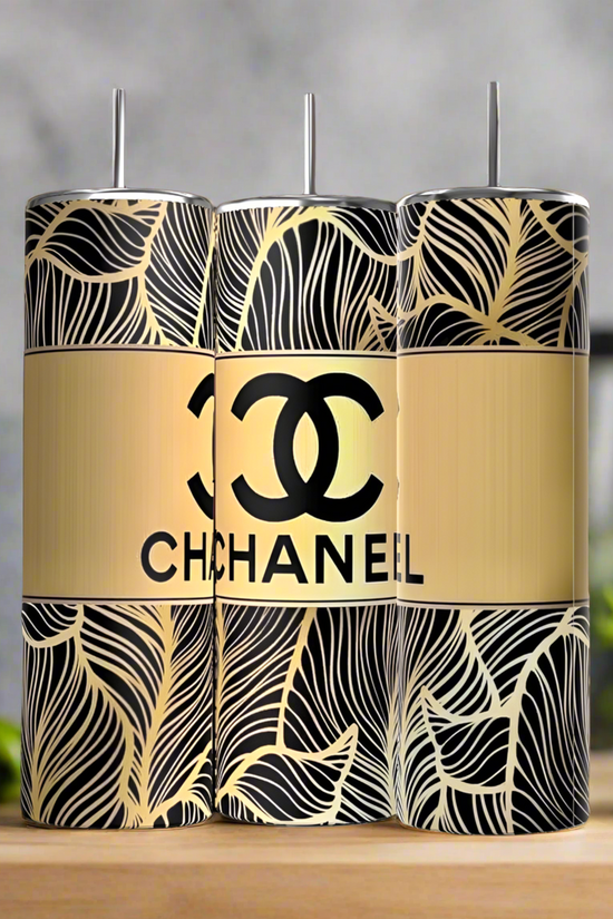 Three Chanel 20oz Skinny Tumblers by Kreative Kreationz, featuring black and gold leaf patterns with a central gold band displaying the Chanel logo and 