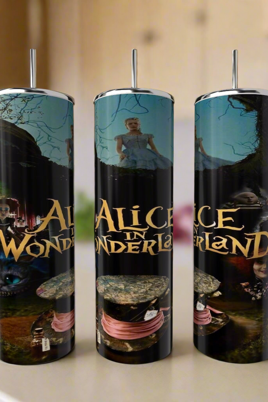 Three Kreative Kreationz Alice in Wonderland 20oz Tumblers, each with metal straw and colorful designs featuring the Cheshire Cat, scenes, and film title, stand on a kitchen counter with a blurred background.