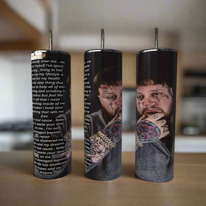 The Kreative Kreationz Jelly Roll “Save Me” Lyrics 20oz Tumbler shows a thoughtful man with facial and hand tattoos, plus white song lyrics on a black background, perfect for use in your kitchen.