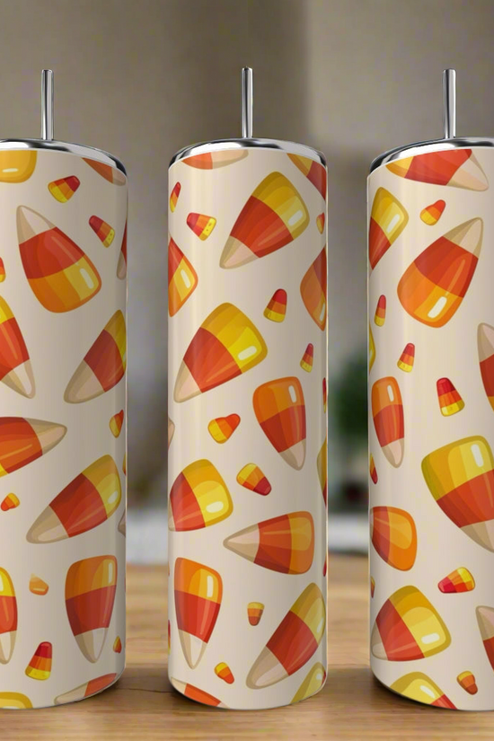 Three Kreative Kreationz Candy Corn 20oz Tumblers are displayed on a kitchen counter, each featuring a vibrant candy corn pattern on cream—perfect Halloween drinkware.