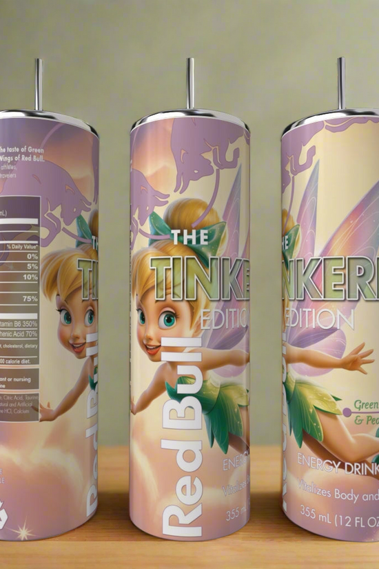 Three cans of Red Bull energy drink, The Tinkerbell Edition with green apple & pear flavor, are next to a Kreative Kreationz Red Bull Tinkerbell Edition 20oz tumbler on a wooden surface, showing clear branding and nutrition facts.