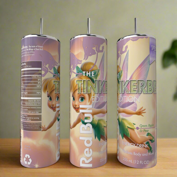 Three cans of Red Bull energy drink, The Tinkerbell Edition with green apple & pear flavor, are next to a Kreative Kreationz Red Bull Tinkerbell Edition 20oz tumbler on a wooden surface, showing clear branding and nutrition facts.