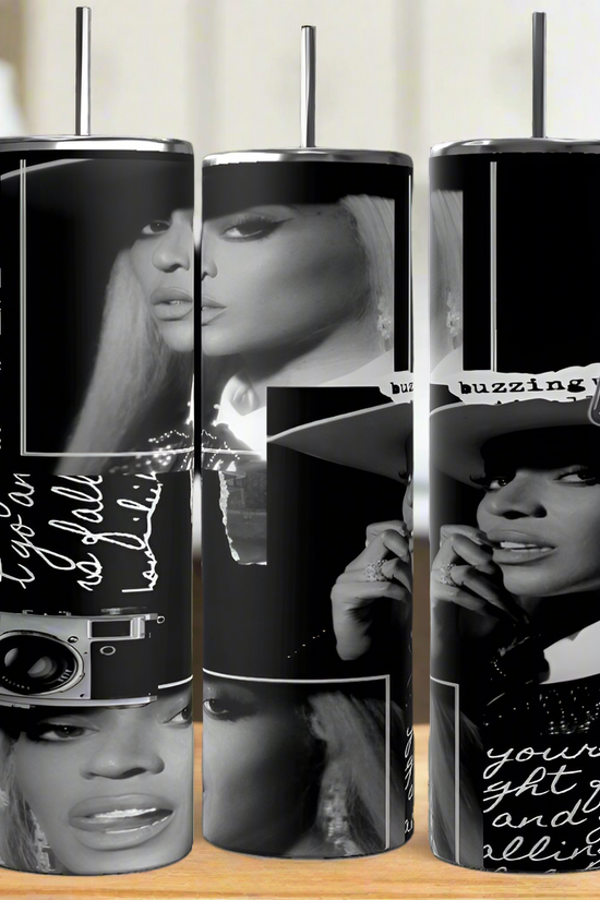 Three tall, cylindrical stainless steel tumblers, the Beyonce 20oz by Kreative Kreationz, feature black and white fashion-themed designs with a woman's face in various poses. Each tumbler is intricately sublimated with text and artistic graphics like a camera, elegantly resting on a wooden surface.