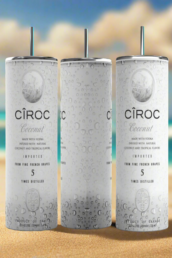 Two cans of Kreative Kreationz Ciroc 20oz Tumbler with 3D Lid Topper are shown on a wooden surface, reminiscent of travel tumblers. The left can is Red Berry flavor, topped with ice and a cherry. The right can is Vodka Snap Frost flavor, topped with ice and a lemon slice. Both cans feature product information and branding.