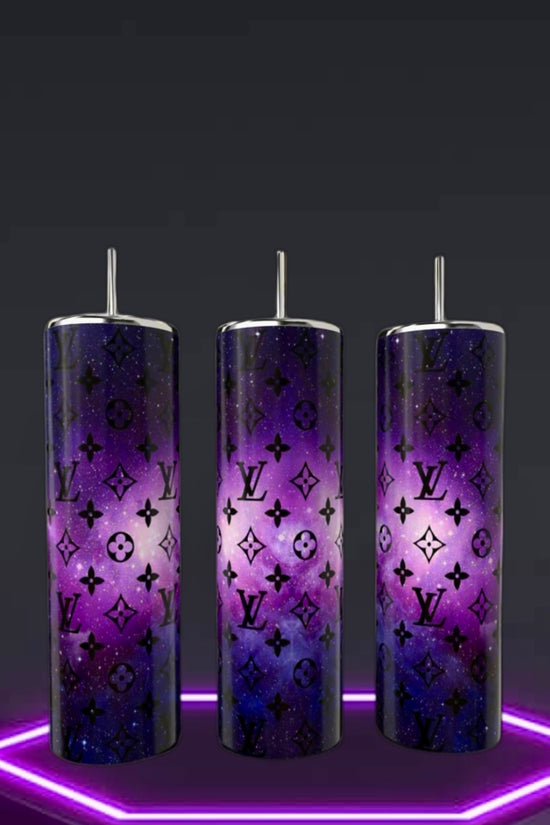 Three Kreative Kreationz LV Cosmo 20oz Skinny Tumblers, featuring double-wall stainless steel and reusable metallic straws, display a purple cosmic pattern with black LV monograms. They're perfectly arranged on a glowing hexagonal neon base against a dark background.
