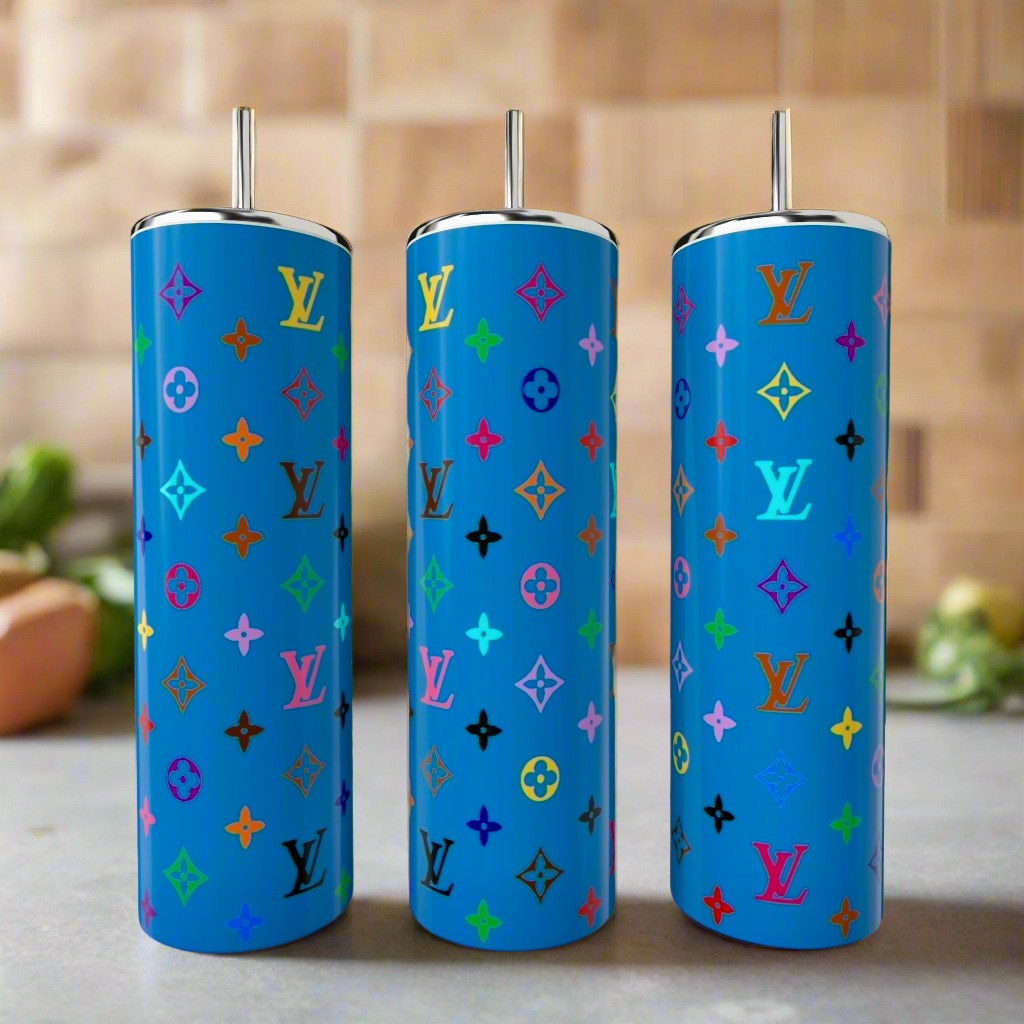 Three LV Blues 20oz Tumblers by Kreative Kreationz with colorful repeating Louis Vuitton monograms and metallic straws stand together against a blurred kitchen backdrop. Each luxury stainless steel piece is tall and blue.