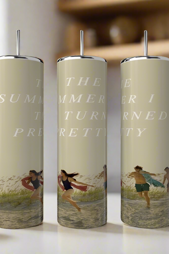 Three Kreative Kreationz Team Belle Collection 20oz tumblers with straws rest on a kitchen counter, each decorated with “The Summer I Turned Pretty” and vibrant waterside summer scenes.