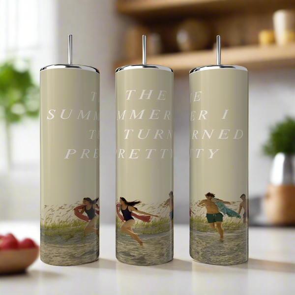 Three Kreative Kreationz Team Belle Collection 20oz tumblers with straws rest on a kitchen counter, each decorated with “The Summer I Turned Pretty” and vibrant waterside summer scenes.