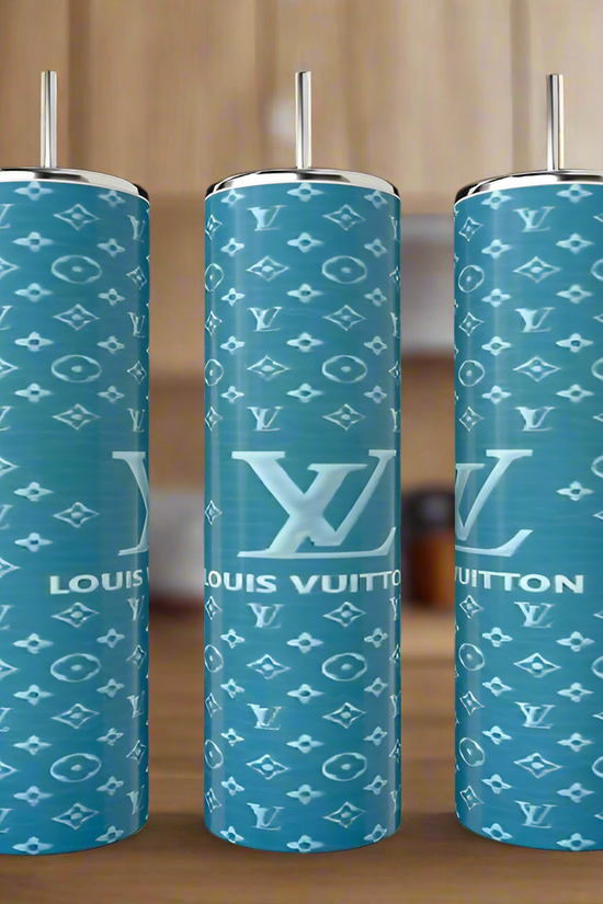 Three Teal LV 20oz Tumblers by Kreative Kreationz, each tall and cylindrical with straws, feature a teal background and white Louis Vuitton-inspired patterns, displayed on a wooden surface with a blurred kitchen backdrop.