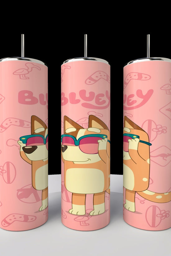 Three pink cylindrical Bluey tumblers featuring a cartoon dog in sunglasses, game controllers, and 