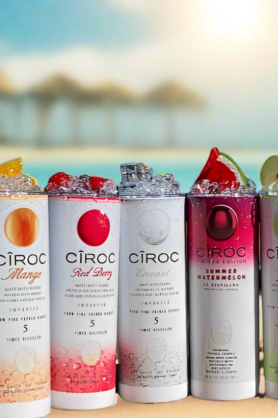 Two cans of Kreative Kreationz Ciroc 20oz Tumbler with 3D Lid Topper are shown on a wooden surface, reminiscent of travel tumblers. The left can is Red Berry flavor, topped with ice and a cherry. The right can is Vodka Snap Frost flavor, topped with ice and a lemon slice. Both cans feature product information and branding.