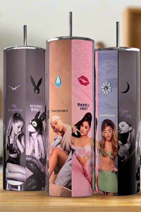 Three Kreative Kreationz Ariana Grande Albums 20oz stainless steel tumblers, each featuring different album or era themes, stand on a wooden surface in a modern kitchen with a softly blurred background for an eco-friendly touch.