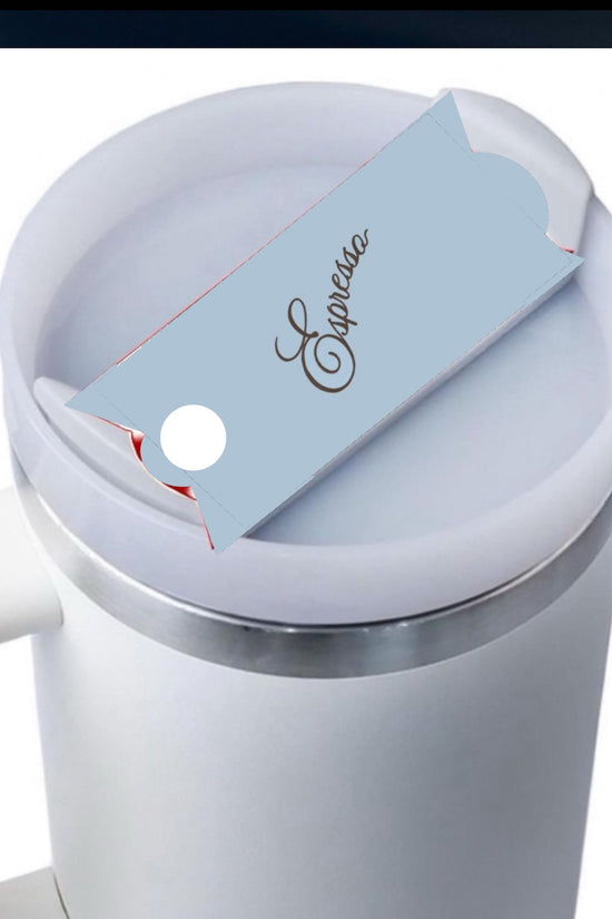 Top view of a beige coffee cup with a white rim. A small thin card with the word 
