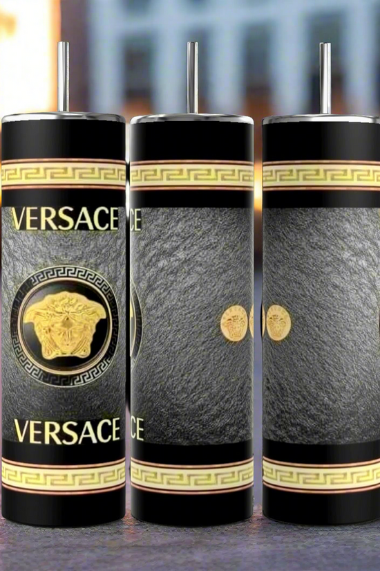 Three dark blue cylindrical tumblers, inspired by the luxury GUCCI Diana design and crafted by Kreative Kreationz, each featuring a textured pattern. These elegant tumblers boast prominent gold and red buckle designs, include a reusable straw, and flaunt a sleek, minimalistic aesthetic against a dark blue background. Each tumbler has an impressive 20 oz capacity.
