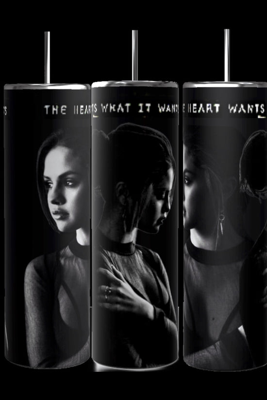 The Selena Gomez The Heart Wants What It Wants 20oz Stainless Steel Tumblers by Kreative Kreationz feature monochrome images of a young woman in contemplative poses against a dark background. The phrase 