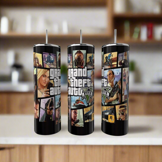 Three Kreative Kreationz Grand Theft Auto 20oz Tumblers with stainless steel straws are shown on a kitchen counter, each featuring vibrant designs and the 